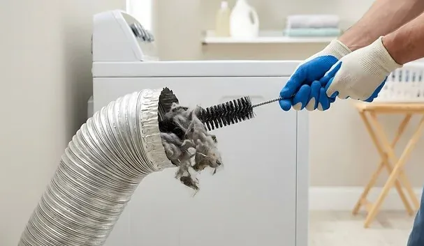 Long brush pulling lint out of a condo dryer vent duct